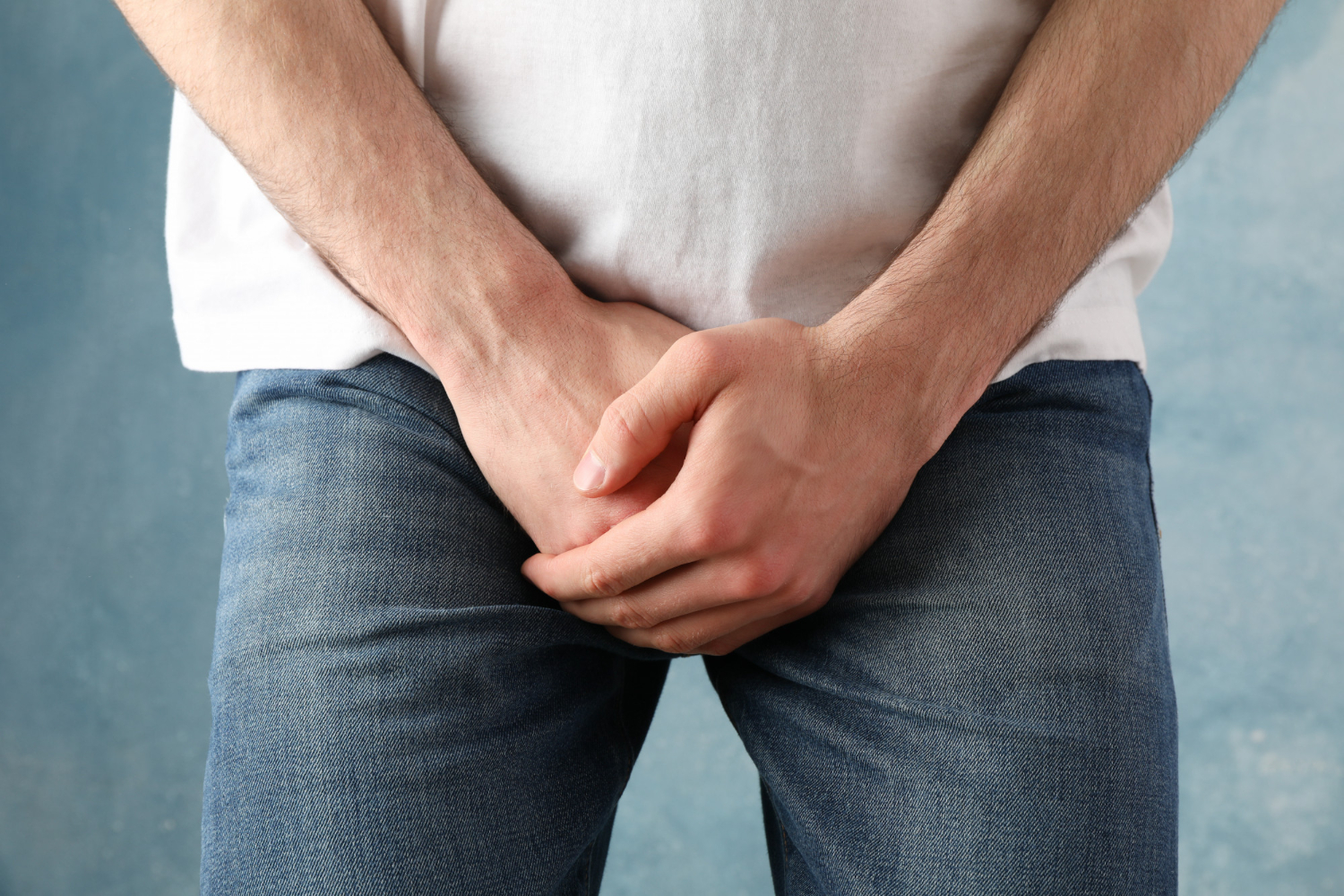 man-holds-his-crotch-blue-close-up